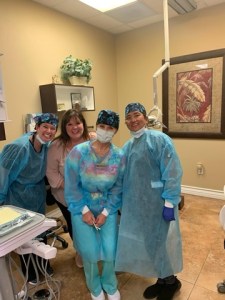Dentist treating patient in chair &mdash; clinic setting with balloons in background