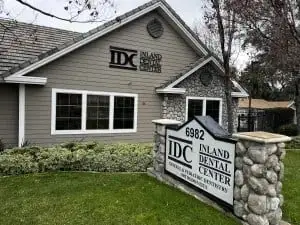 Inland Dental Center — gray building with stone sign at 6982, green lawn