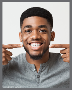 Man smiling broadly, pointing to his healthy white teeth