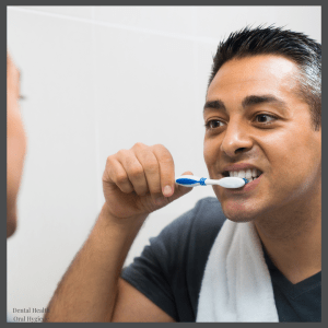 Man brushing teeth in front of mirror — daily dental care routine