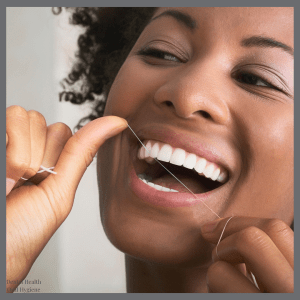 Woman flossing with a bright smile — promoting oral hygiene